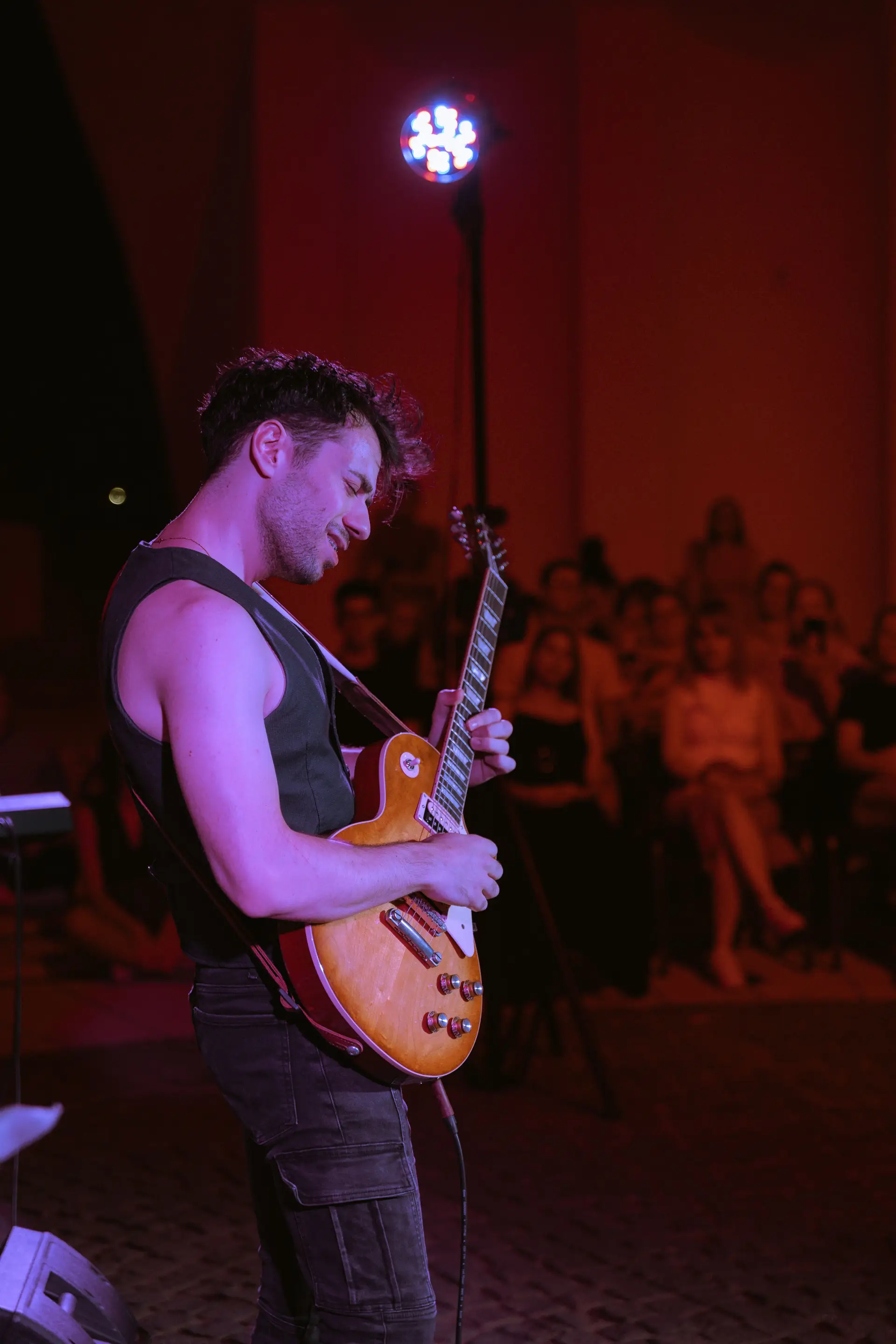 Guitarist under colorful stage lights