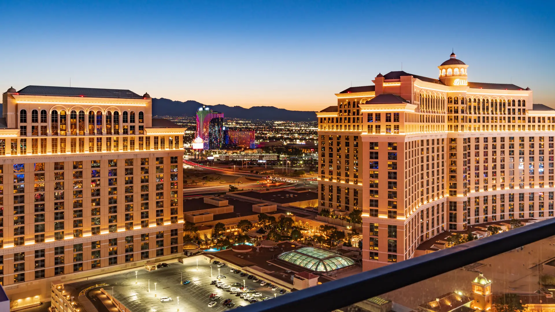 Aerial twilight view of premium casino hotel suites overlooking the vibrant illuminated city skyline